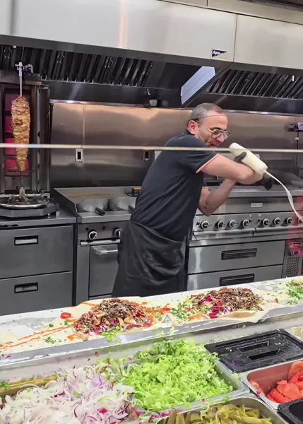 A shawarma chef turning preparation into a show